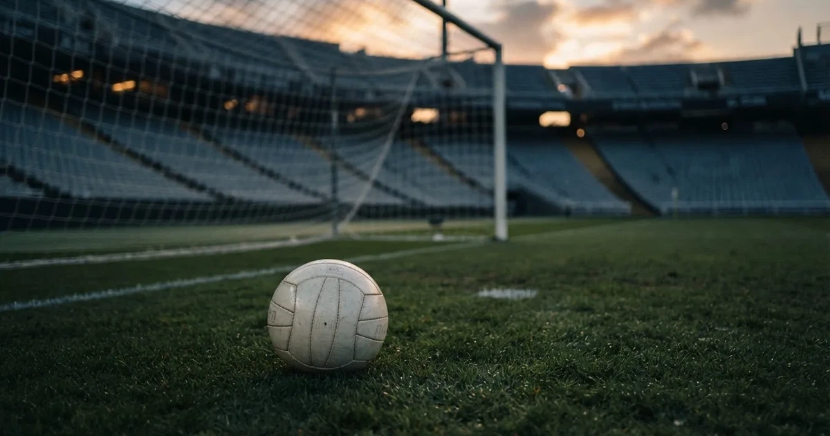 Ein Fußball liegt im Strafraum direkt vor dem Tor mit Netz, im Hintergrund leere Ränge bei Dämmerung.